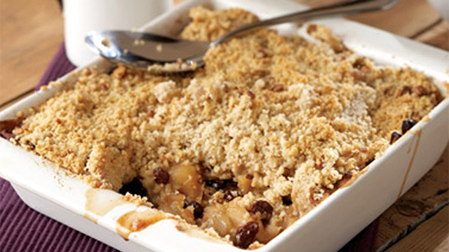 Bramley Apple and Raisin Crumble served in a white dish