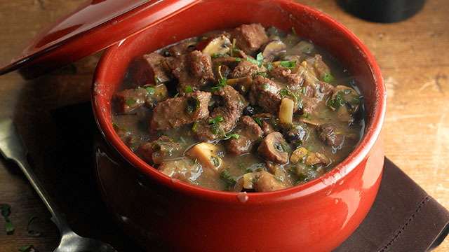 Beef casserole with chesnuts, mushrooms and winter spice served in a casserole dish and sprinkled with parsley