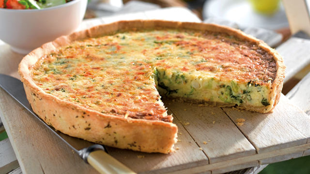 Crab and watercress quiche with a portion missing to see the inside
