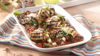 Grilled Aubergine with Tomato and Feta served on a tomato sauce in a white dish