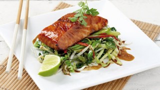 Oriental Style Salmon served with a lemon wedge on a white dish with chopsticks