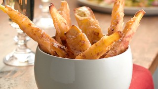 Parmesan Parsnip Twiglets sprinkeld with sea salty served in a white bowl