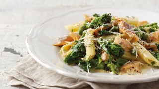 Flaked Trout with Penne Pasta and Purple Sprouting Broccoli topped with parmesan served on a white plate