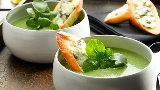 Watercress and Roast Garlic Soup Served with Roquefort Cheese Slices