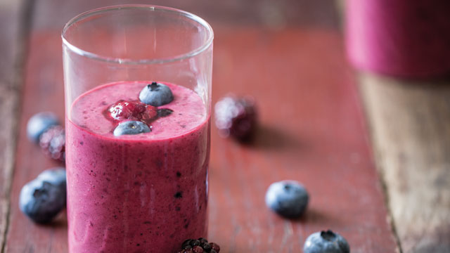 Blackberry and Blueberry Smoothie served in a glass topped with extra blueberries and blackberries