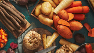 close up image of a selection of root vegetables on a dark blue background