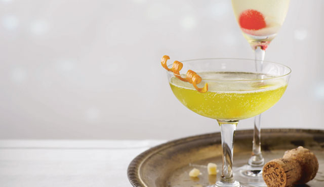 Two champagne cocktails, served in a tray with the relevant garnishes