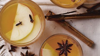 Warming Party Punch served in three glasses with apple slices, star anise and cinnamon sticks