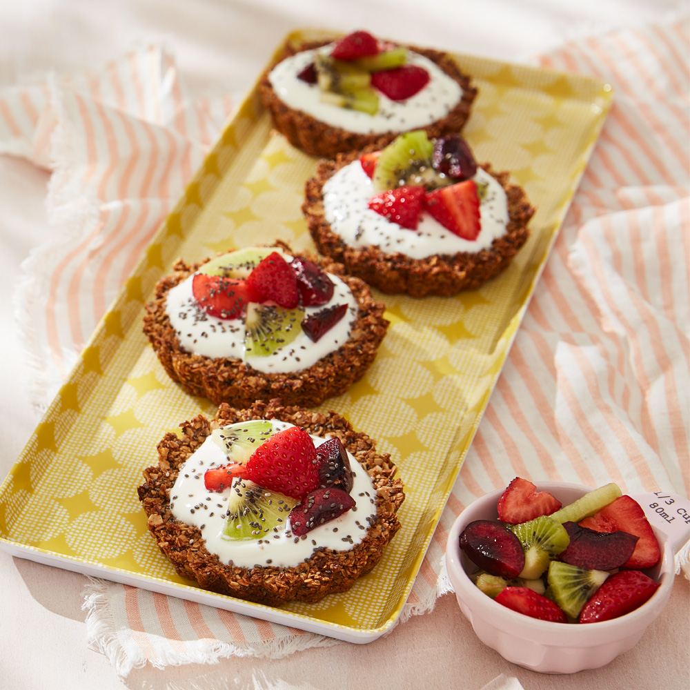 Image of four breakfast granola tarts lined up on a tray