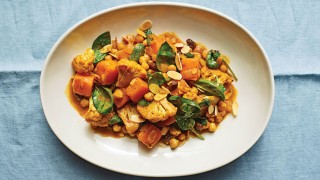 Cauliflower, Squash and Chickpea Curry served in a white bowl on top of a blue tablecloth