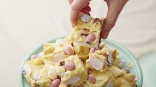 No Bake White Chocolate Mini Egg Rocky Road cut into squares and served on a turquoise plate