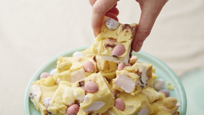 No Bake White Chocolate Mini Egg Rocky Road cut into squares and served on a turquoise plate