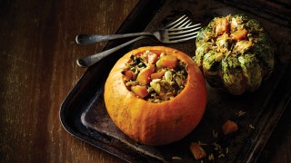 Two chicken and pumpkin byriani servings in a metal tray with a knife and fork