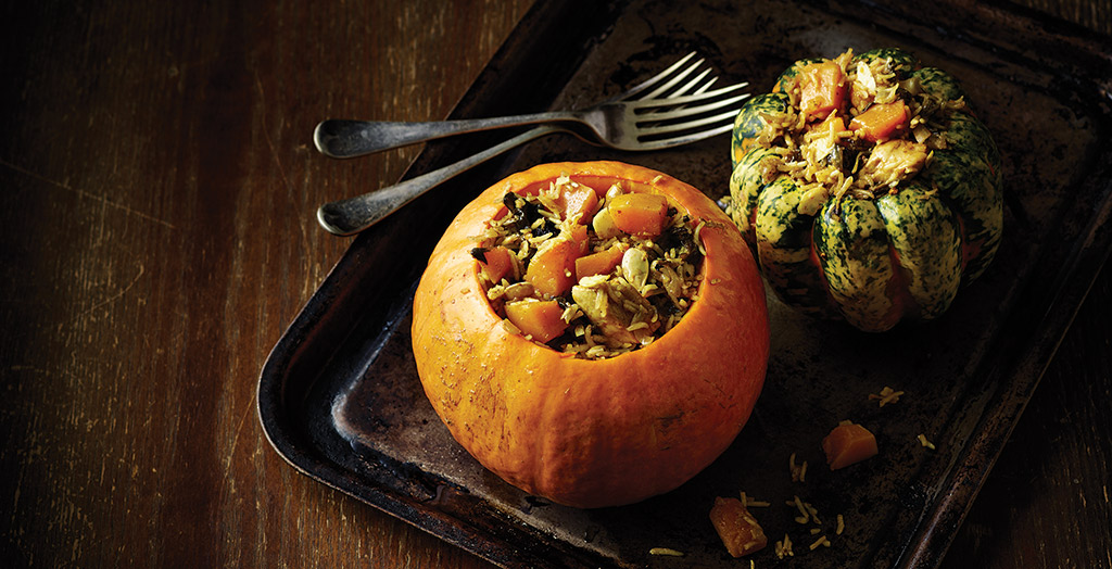 Two chicken and pumpkin byriani servings in a metal tray with a knife and fork