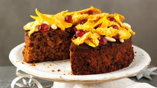 Jamaican Christmas Cake on a white serving plate, with a slice removed to show the inside