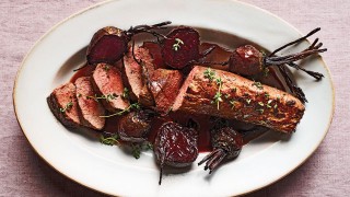 Fillet of Venison with Roasted Vegetable served on a white dish and sliced