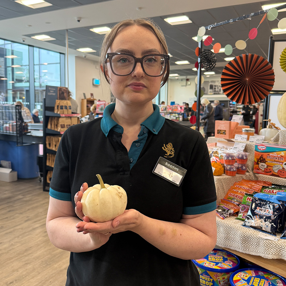 Image of a Booths colleague holding a munchkin pumpkin