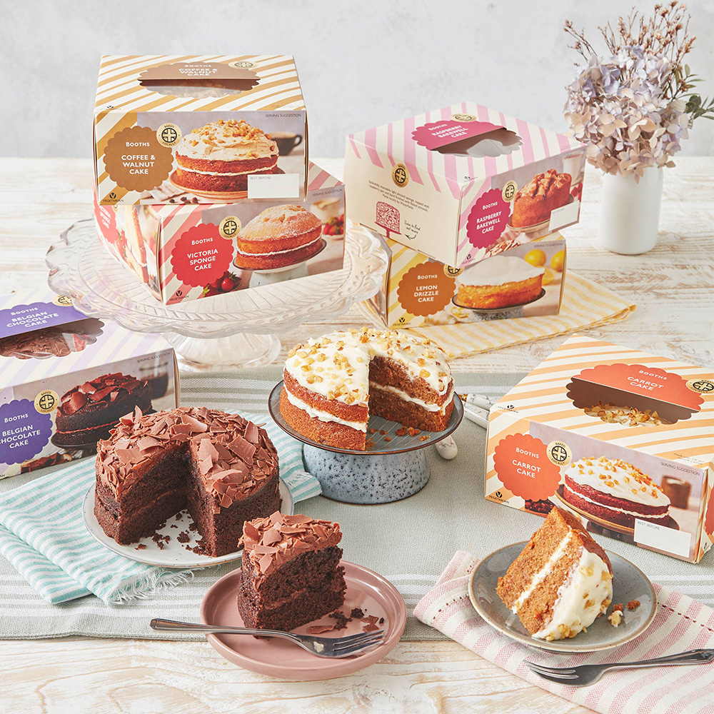 An image of 6 different cake boxes with two cakes in front that have slices taken out of them