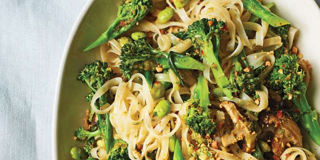 Shiitake Mushroom and Leek Thai Noodles served with broccoli in a white bowl on a white table cloth