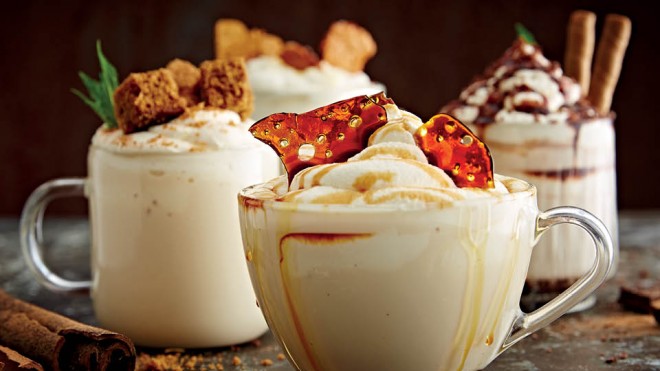 White Hot Chocolate served in glass cups with various toppings including caramel, cinnamon and biscuits