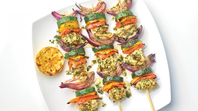 Fish Kebabs with Chermoula Sauce served on a white plate with a wedge of grilled lemon