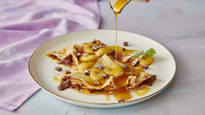 Nutella and Banana Pancakes being drizzled syrup