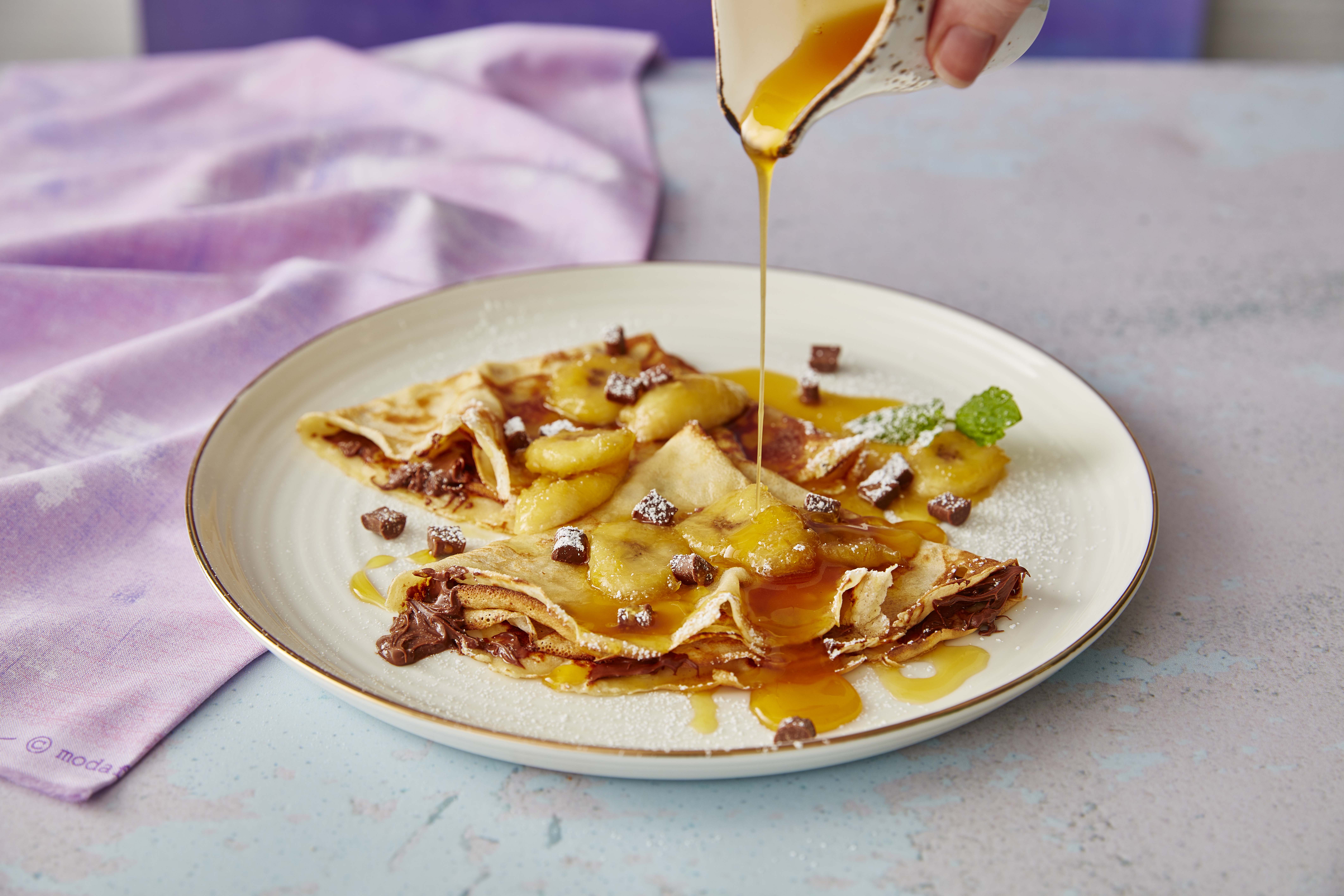 Nutella and Banana Pancakes being drizzled syrup