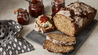 Pear, Blue cheese and Prosciutto Soda Bread sliced and served on a slate, with a jar of chutney