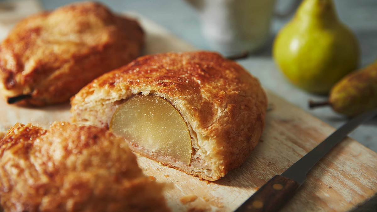 A pear wellington cut in half on a baking tray