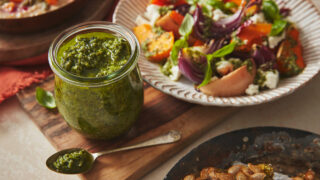 Green pumpkin pesto in a glass jar served with an Autumnal salad