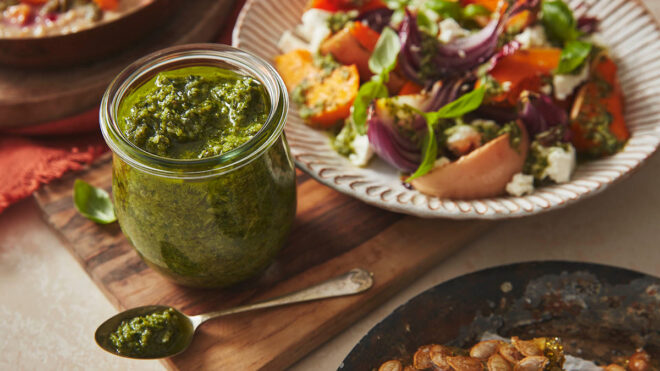 Green pumpkin pesto in a glass jar served with an Autumnal salad