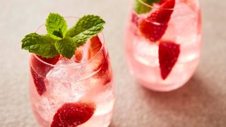 Rhubarb and Rosehip Cocktail served in two glasses with sliced strawberries and fresh mint