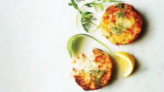 Smoked Salmon, Dill and Caper Fishcakes served on a marble slab with lemon wedges and rocket