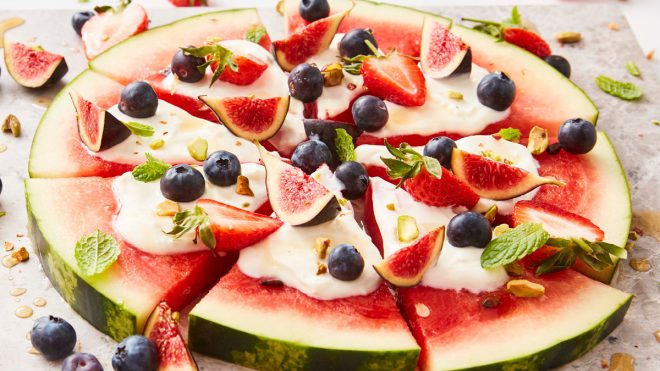 Watermelon Pizza sliced and topped with figs, strawberries and blueberries