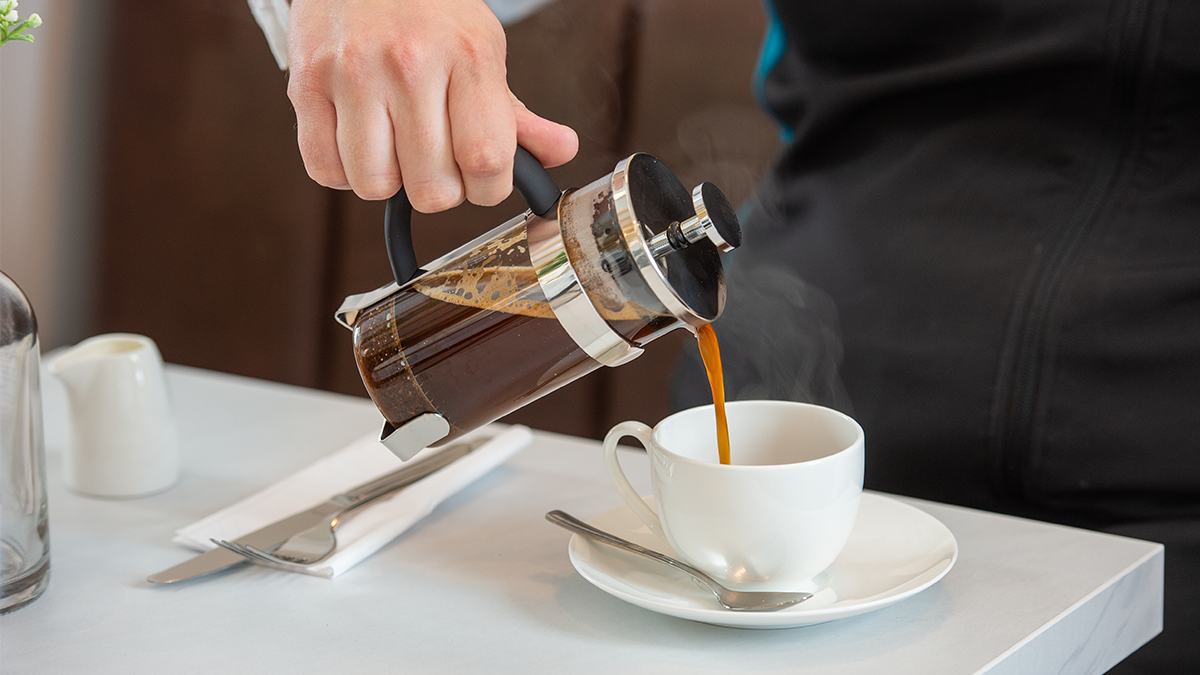 Image of someone pouring a cup of coffee