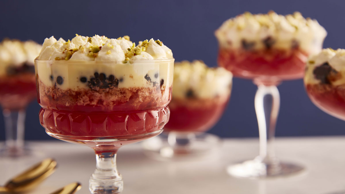 Blackberry and Amaretti Trifles served in glass dishes and topped with pistachio nuts