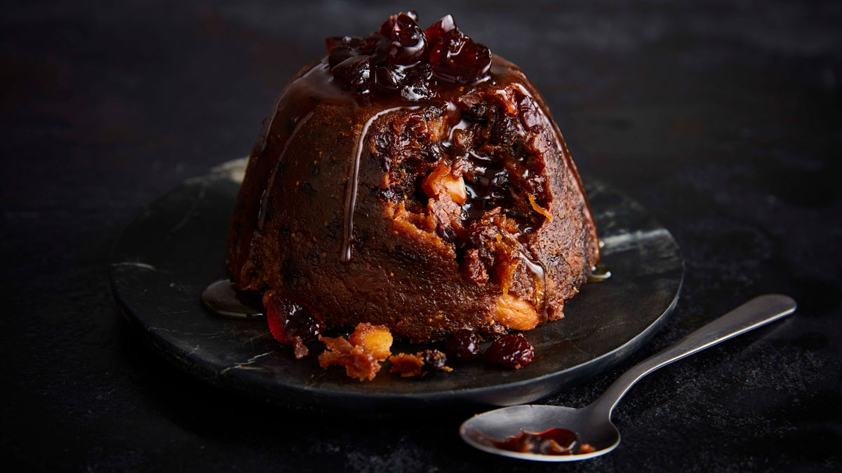 Amaretto Christmas Pudding served on a marble plate next to a spoon