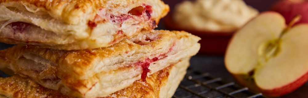 Apple Turnovers stacked on top of each other served on a cooling rack