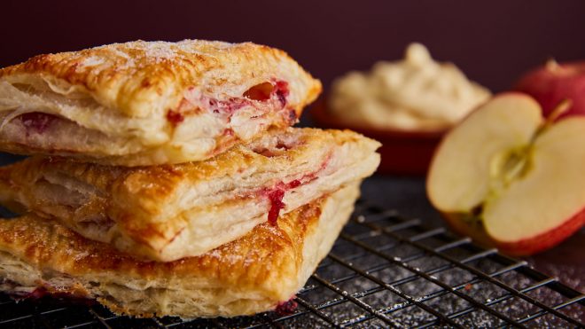 Apple Turnovers stacked on top of each other served on a cooling rack