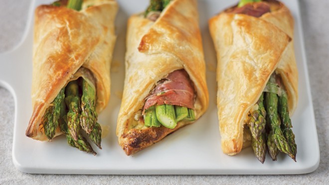 Three Asparagus and Parma Ham Pastries served on a white board