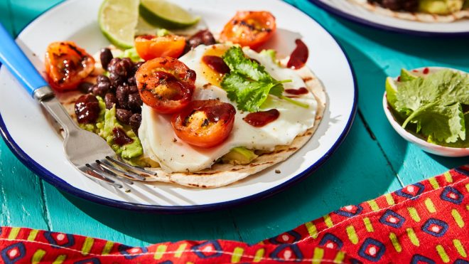 Avocado and Black Bean Breafast Tacos topped with coriander and lime wedges