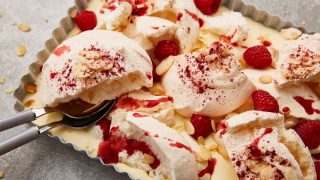 Bakewell Meringue Pie served in a baking tin with two spoons removing a slice