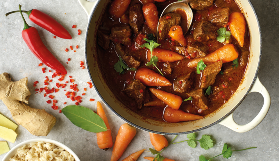 Spiced Beef and Coconut Curry served in a casserole dish topped with parsley