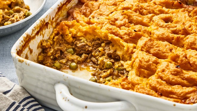 Spiced Beef and Lentil Bake with Sweet Potato Topping served in a white casserole dish with a portion removed to see the filling