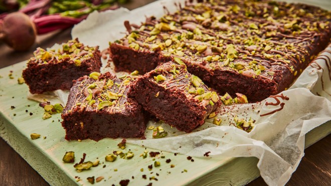 Beetroot Brownies topped with pitachios, served on baking parchment and sliced