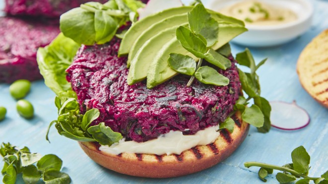 Beetroot Burger served on a toasted brioche bun, with mayonnaise, sliced avocado and watercress