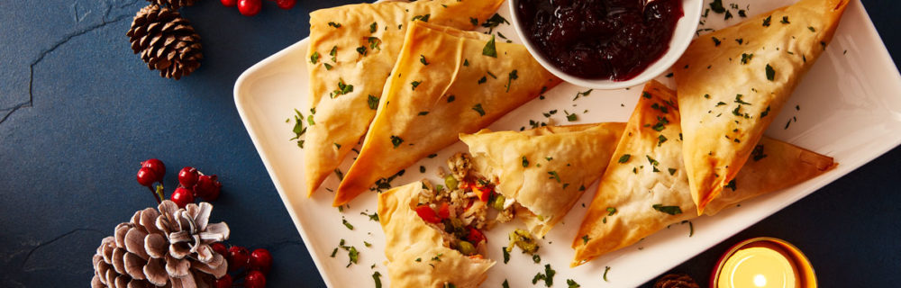 Festive Filo Parcels served on a white plate with a dish of cranberry sauce