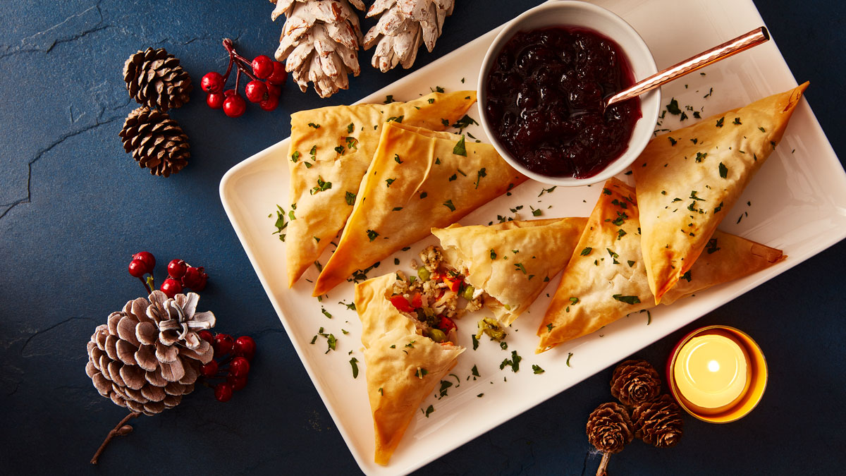 Festive Filo Parcels served on a white plate with a dish of cranberry sauce