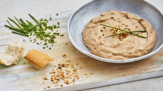 Easy Breadsticks with Black Garlic Dip served in a bowl, on a wooden board with chopped chives