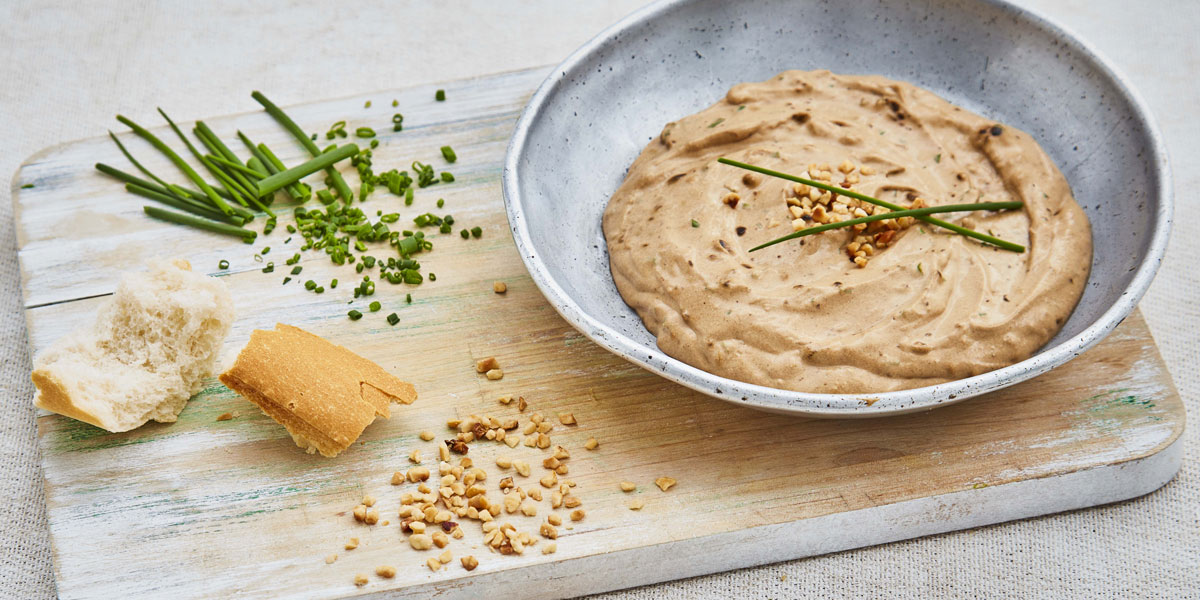 Easy Breadsticks with Black Garlic Dip served in a bowl, on a wooden board with chopped chives